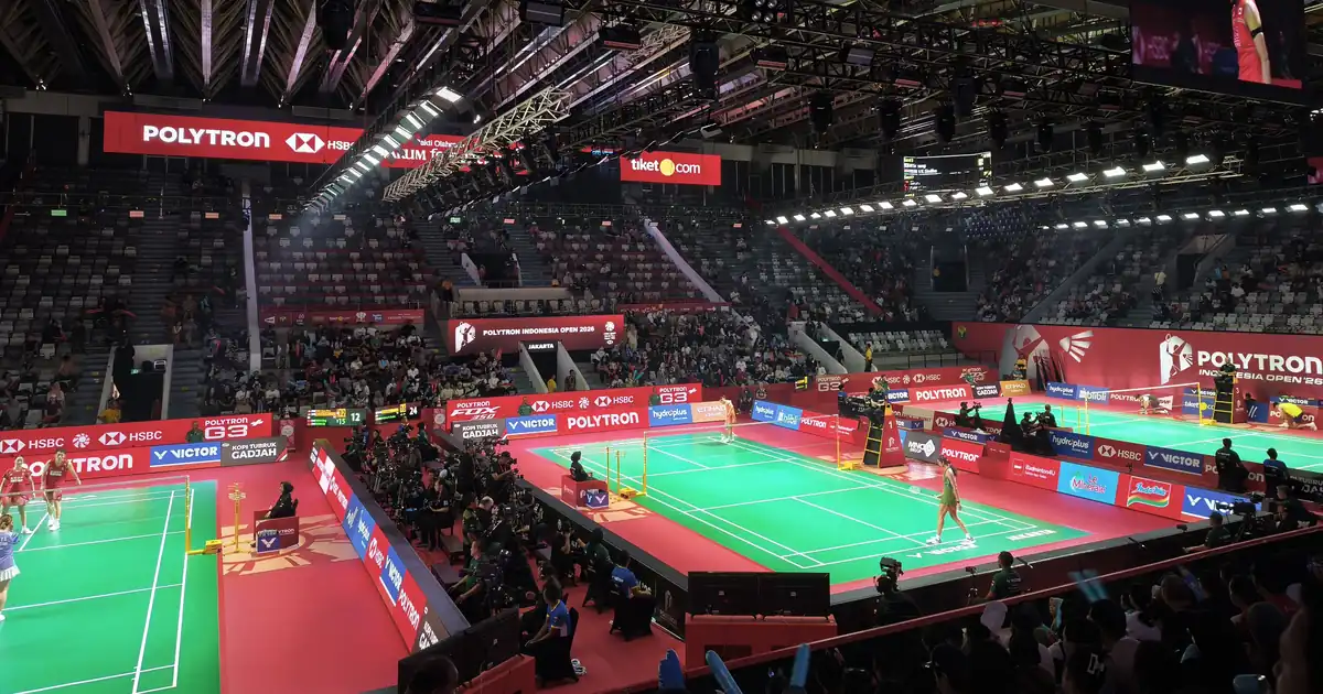 Suasana Istora Senayan Jakarta saat Indonesia Open 2026 dengan beberapa lapangan hijau, papan iklan merah, dan penonton di tribun