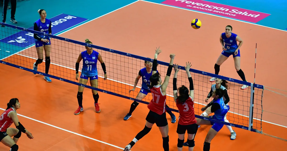 Pemain voli putri Argentina dan Korea Selatan berebut bola di depan net di lapangan oranye