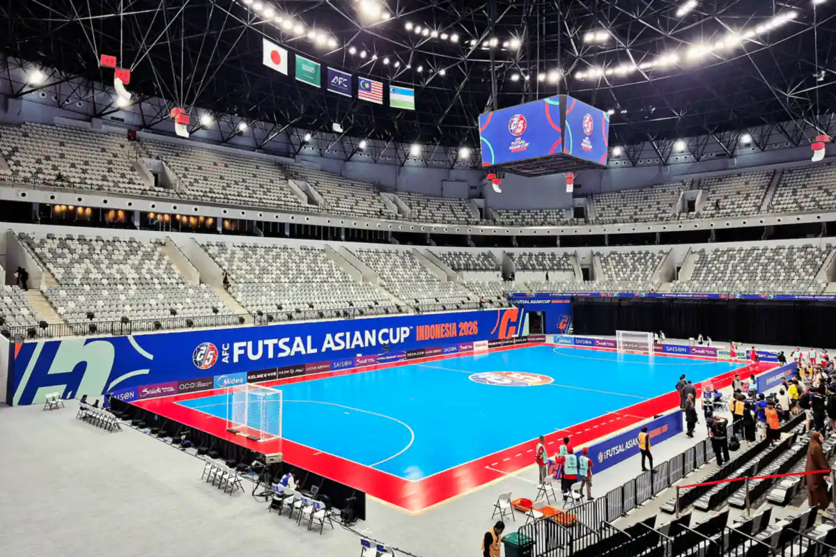 Lapangan futsal biru di dalam Indonesia Arena saat Piala Asia Futsal AFC 2026, dengan tribun dan papan iklan di sekelilingnya