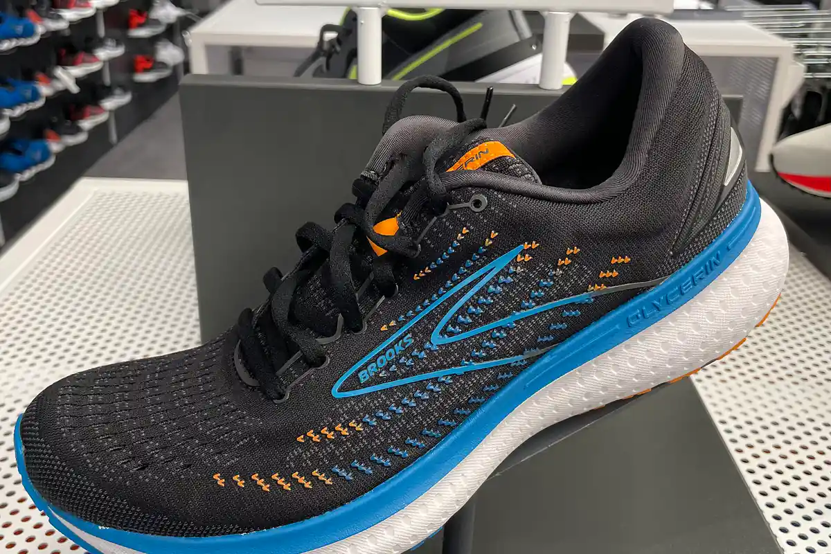 Sepatu lari Brooks Glycerin 19 hitam dengan midsole putih biru di rak pajang toko