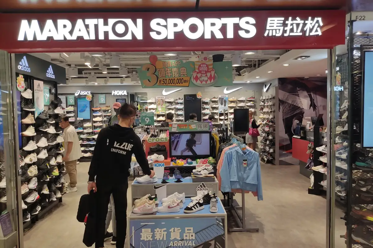Pintu masuk toko Marathon Sports di sebuah mal di Hong Kong dengan rak sepatu di dalamnya