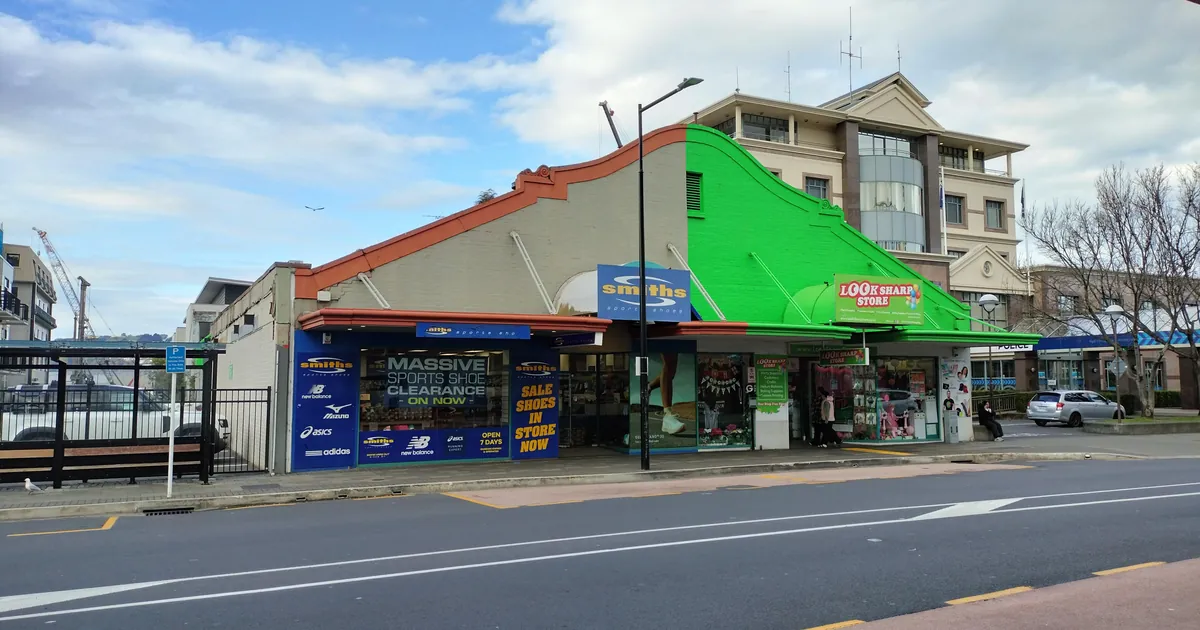 Deretan toko di tepi jalan, termasuk toko Smiths Sports Shoes, di Dunedin, Selandia Baru